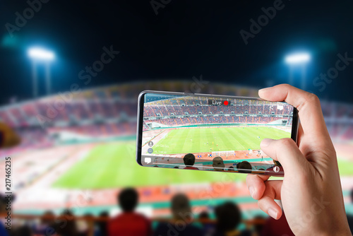 People hands use smartphones record soccer competition match in football stadium live streaming video on internet to social media comment chat to Friend