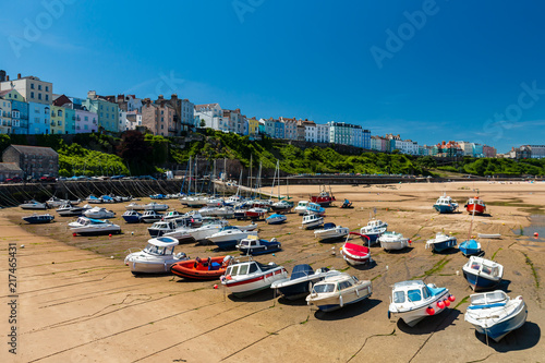 Colorful boats aground on the sand at Tenby Harbour at low tide © whitcomberd