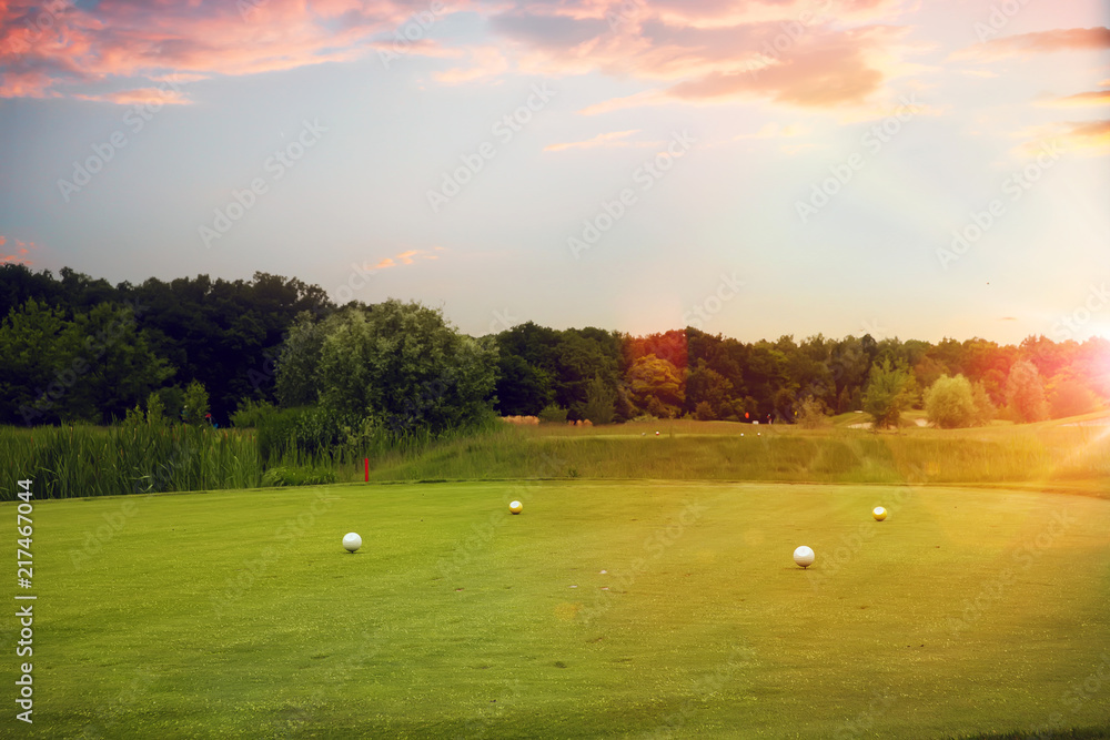 Four white balls on golf course, launching point Four white balls on golf course, launching point