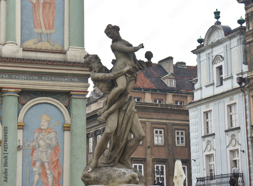 Fototapeta premium Picture on the wall of Town hall (Ratusz Poznanski) and beautiful sculpture in old town of the city, market square, sunny day, Poznan, Poland