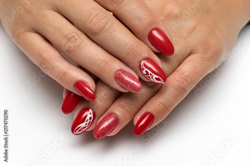 bright red manicure with a white abstraction and sequins on long oval nails