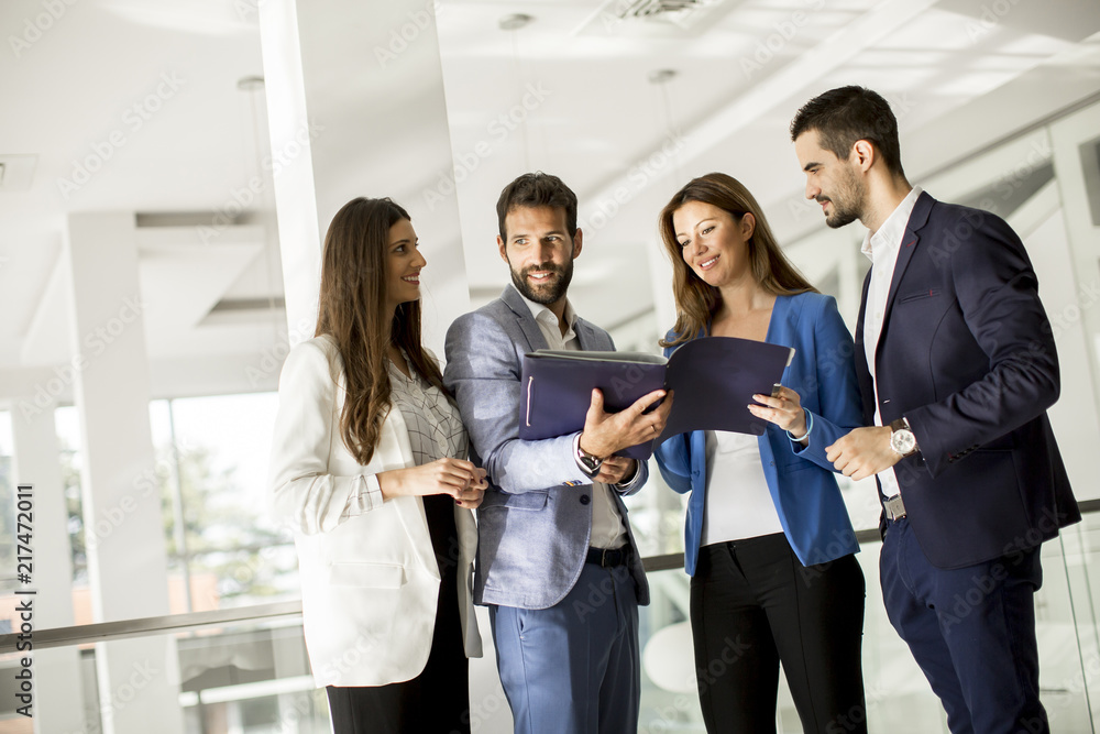 Young business people standing and analyzing documents Young business people standing and analyzing documents