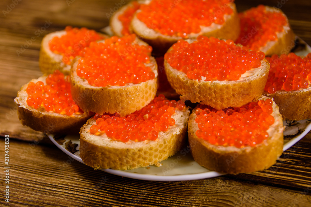 Sandwiches with red caviar on wooden table Sandwiches with red caviar on wooden table