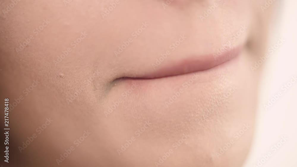 Close up portrait of attractive girl rouging her lips. She is holding rose lipstick. Her mouth is gently open. Close up portrait of attractive girl rouging her lips. She is holding rose lipstick. Her mouth is gently open.
