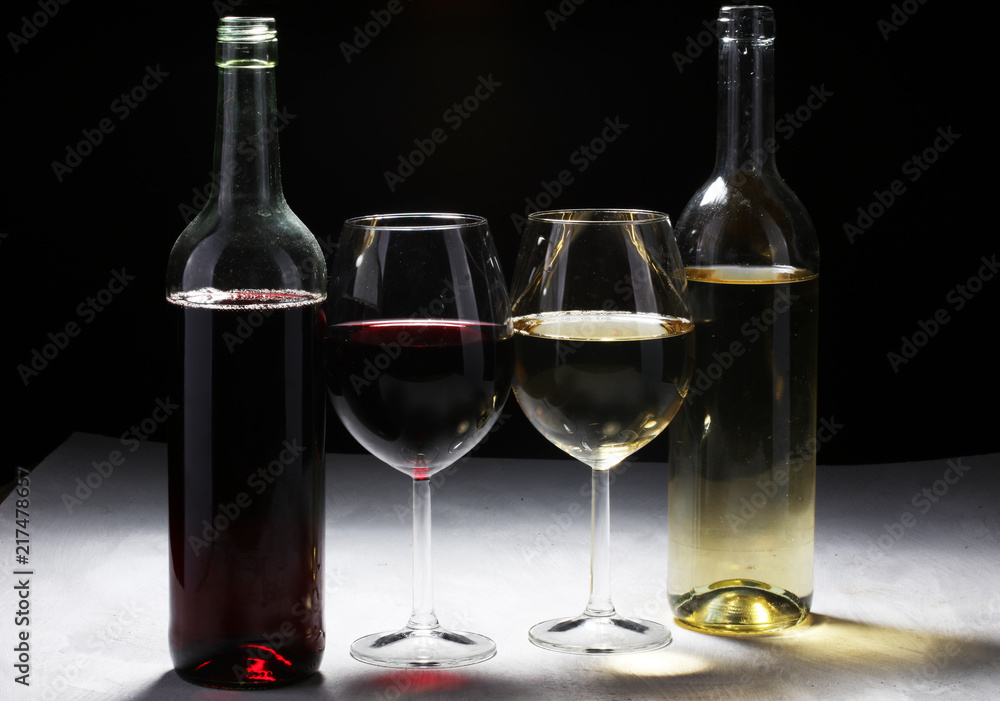 White wine and red wine in a glass on white stone background.