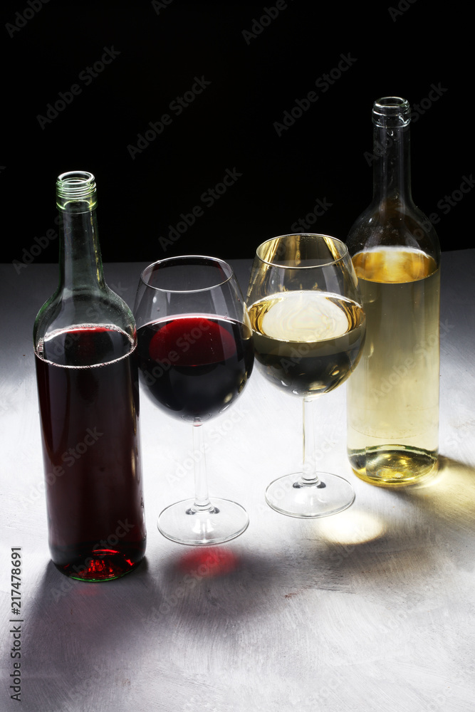 Obraz premium White wine and red wine in a glass on white stone background.