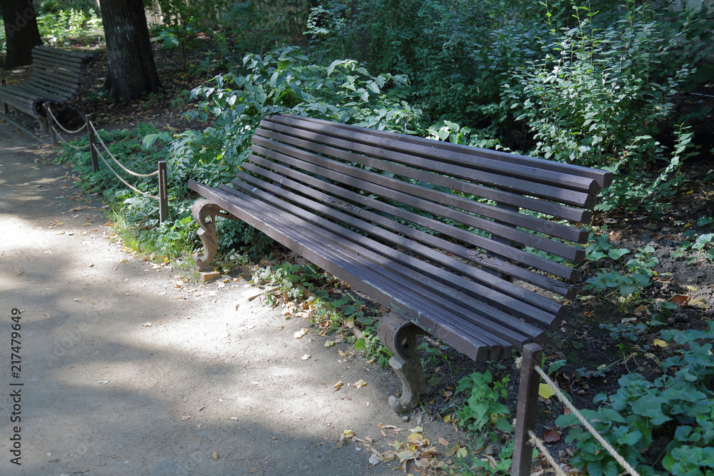 Old-fashioned wooden bench for rest in summer city park
Old-fashioned wooden bench for rest in summer city park