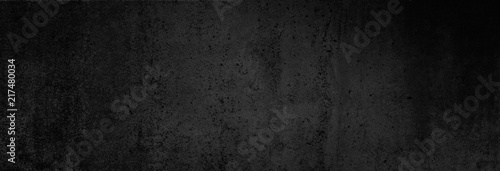 Beton-Textur in fast schwarz in XXL-Größe als Hintergrund, auf die Betonwand fällt ganz leichtes Licht