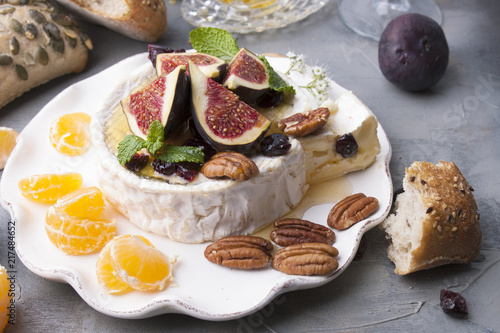 Cheese with white mold and figs, honey and nuts. Autumn sweets and fruits and wine. Delicious food for dinner. Top view