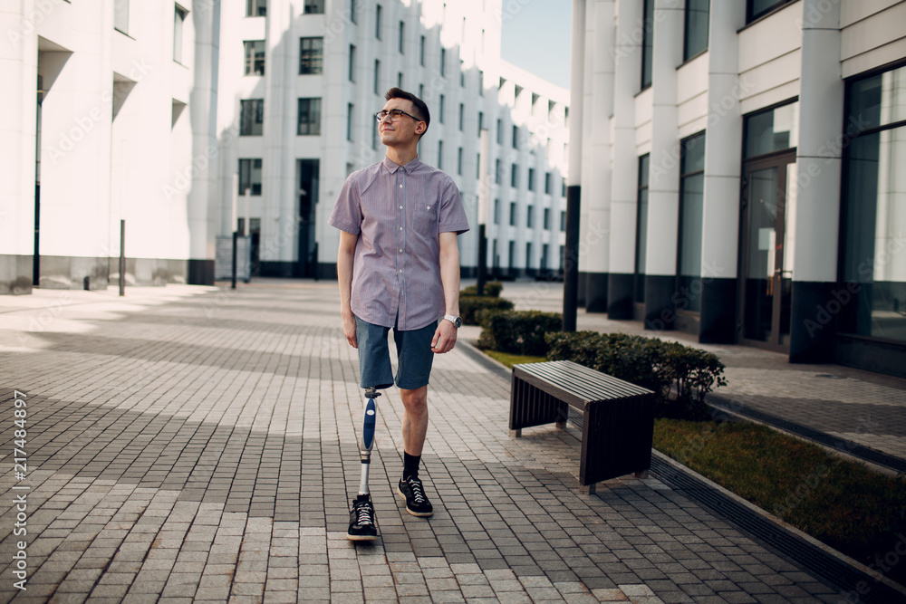 Ταπετσαρία Disabled young man with foot prosthesis walks along the street.