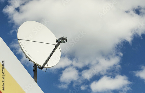 satellite dish on a background of blue cloudy sky