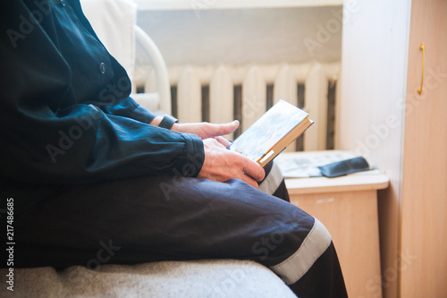 Obraz na plátně Сropped image of prisoner reading book