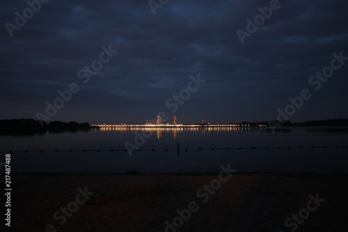 The Nesselande beach and district lights in the evening is reflecting on the water of the Zevenhuizerplas, taken from Oud Verlaat in the Netherlands photo