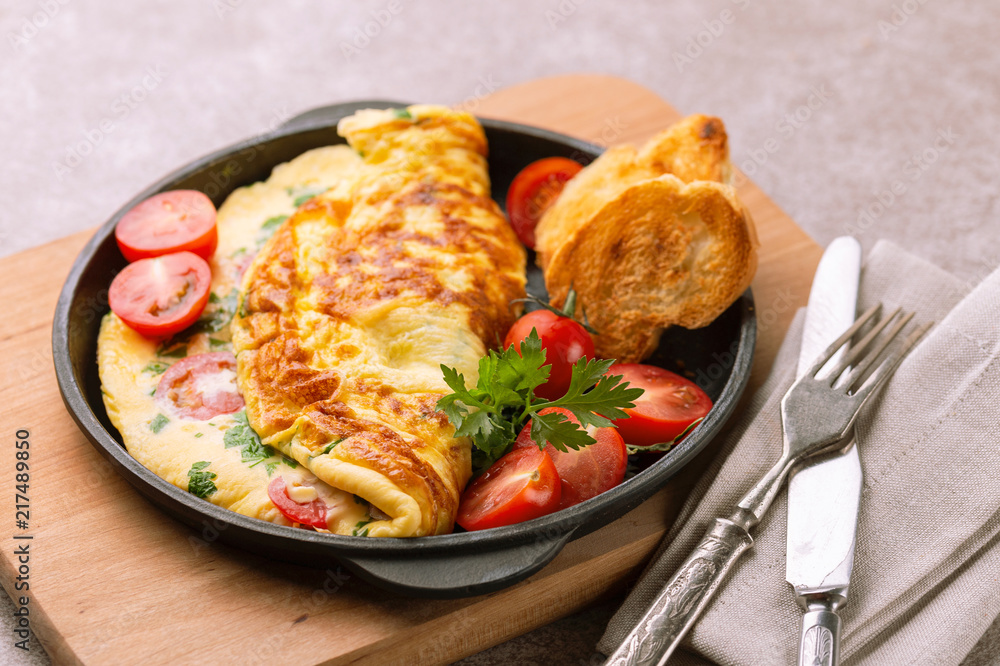 Herb omelette with tomatoes and panini toasts.  Breakfast