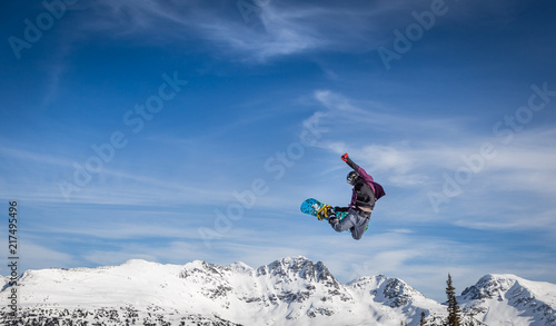 Snowboarder in mid-air grabbing the back of his board.