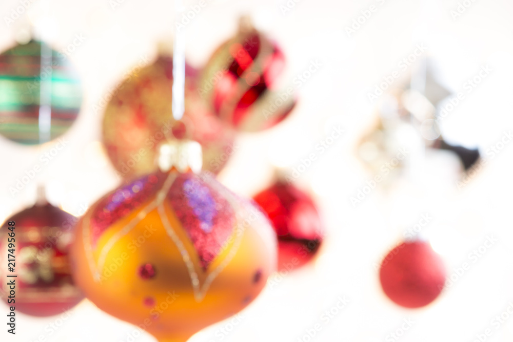 Colorful Christmas tree ornaments hanging from ribbons.  High key background.