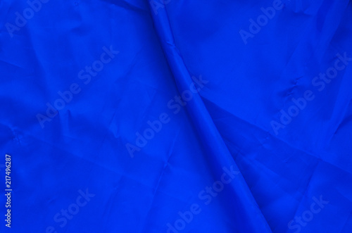 Blue Synthetic Lining Fabric with Folds. Crumpled Sheet or Clothes Background,