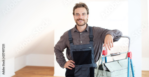 Handwerker sympathisch lächelnd in einem Gebäude  photo