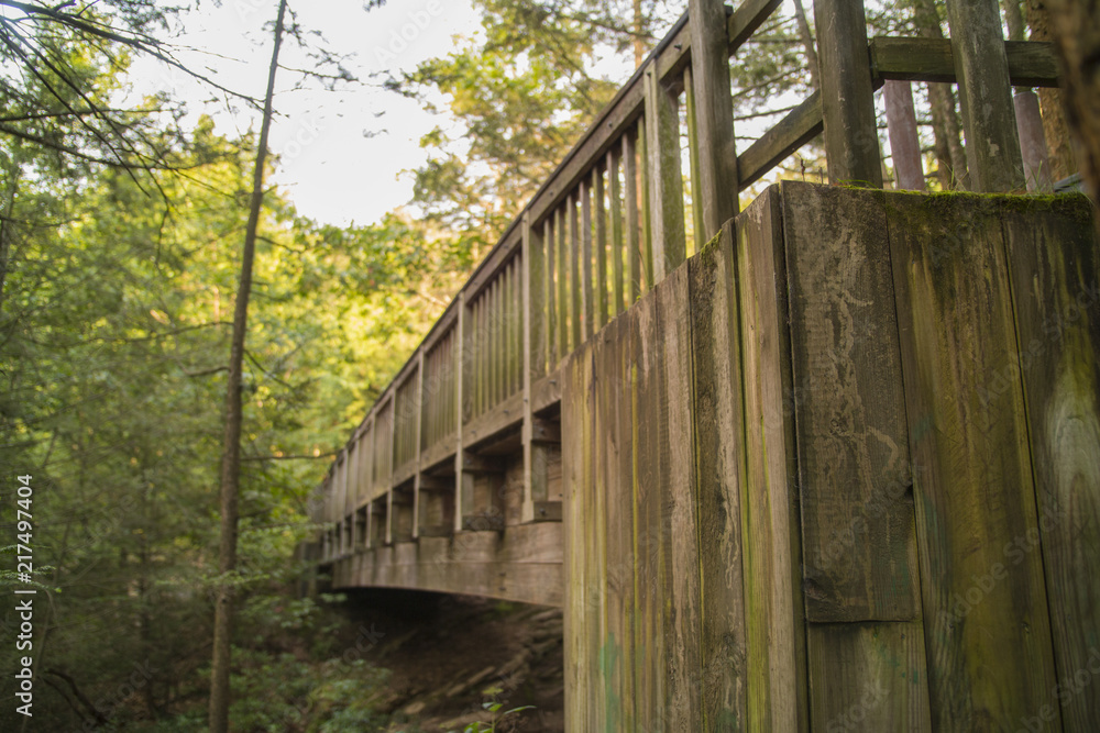 Old Wooden Bridge Spans Gorge And Waterfalls Along Hiking Path