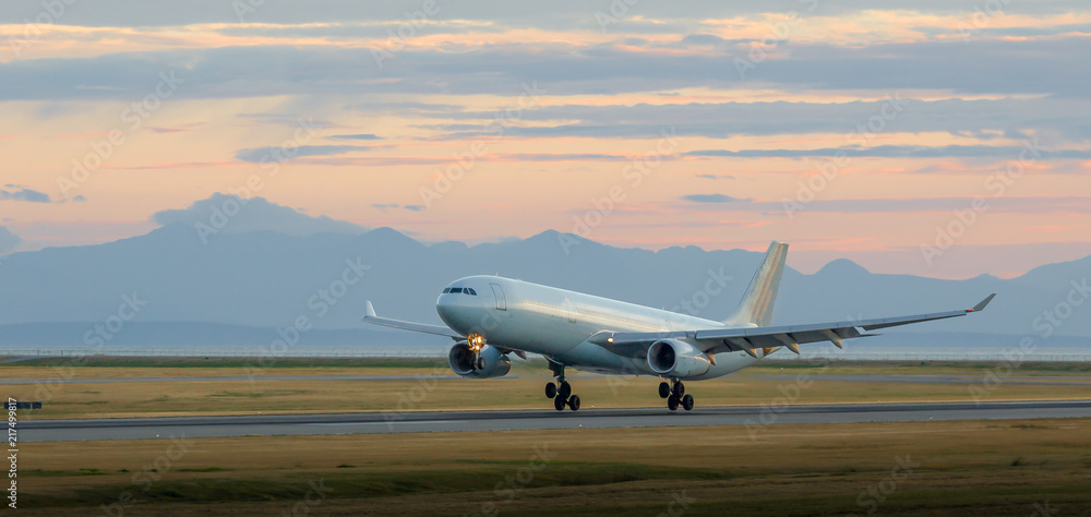 custom made wallpaper toronto digitalAircraft landing at YVR at dusk with mountains in the background.