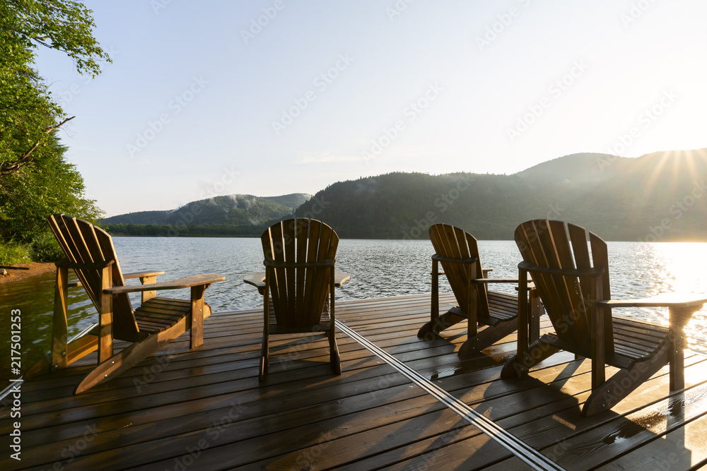 Fototapeta premium Leżaki Adirondack na doku nad jeziorem