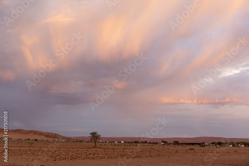 Beautiful sun lit stormy cloudscape above a village in the desert, Namibia
