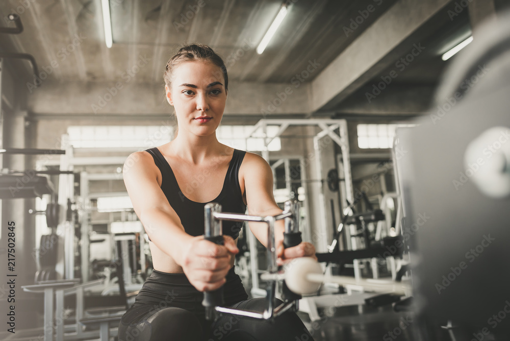 caucasian woman exercising with machine in gym caucasian woman exercising with machine in gym