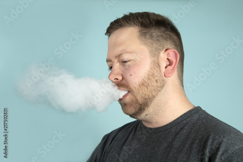 Young man vaping smoking an e-cigarette