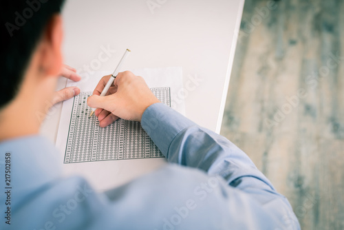 Billede på lærred Man filling out an answer on answer sheet