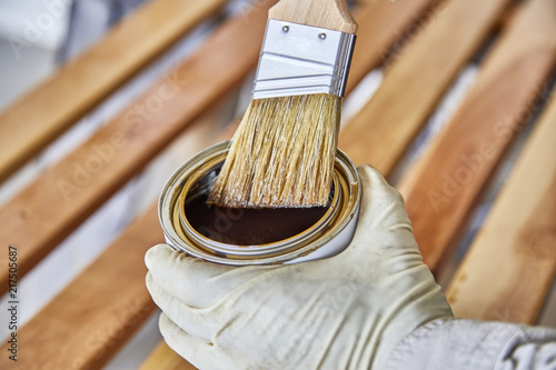 Paint Brush in a can of varnish in preparation to stain the wood slats