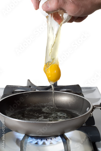 cracked egg falling into frying pan