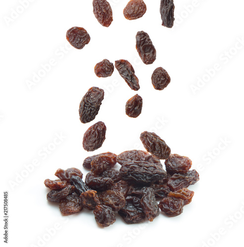 Raisins falling isolated on white background.