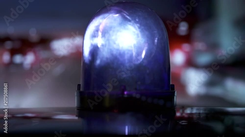 POV driving vehicle with blue flash emergency light on highway at night. Rotating warning beacon mounted on car roof closeup.