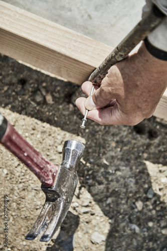 Man using a hammer to fasten down a form stake