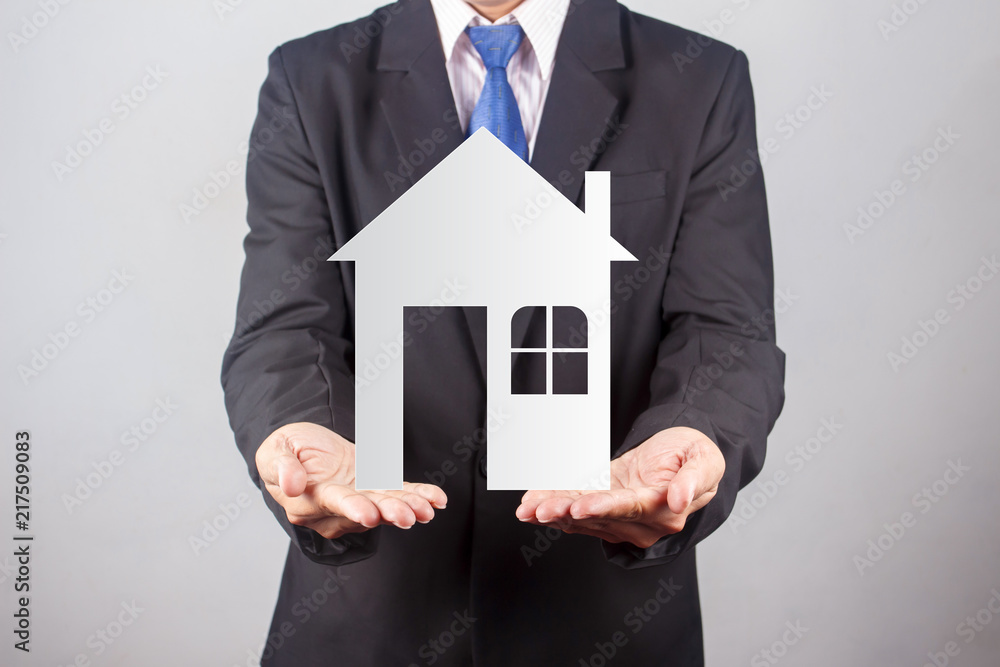 Businessman holding paper house in his hands, Real estate concept Businessman holding paper house in his hands, Real estate concept