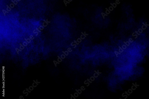 Abstract blue dust explosion on black background. Freeze motion of blue powder splash.