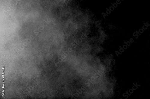 Abstract white powder explosion. White dust debris isolated on black background.