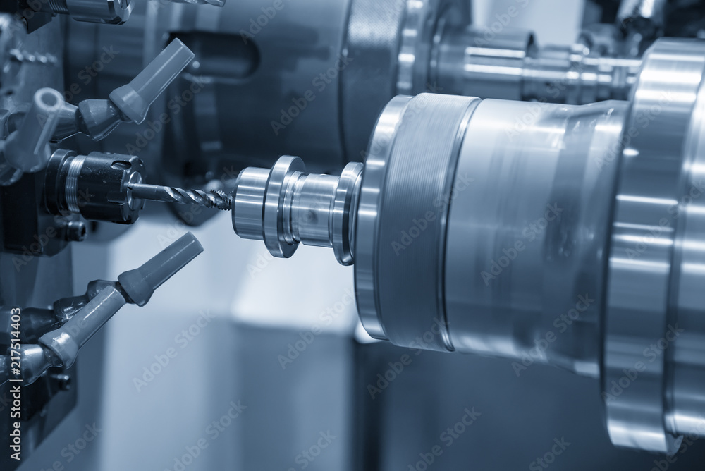 The CNC lathe or turning machine making the thread with the tapping tool the hole at the stainless shaft.Hi-technology manufacturing process. The CNC lathe or turning machine making the thread with the tapping tool the hole at the stainless shaft.Hi-technology manufacturing process.