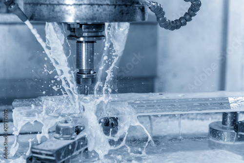 The CNC milling machine cutting the tire mold part with the solid ball end-mill tool and coolant  fluid  in the light blue scene.