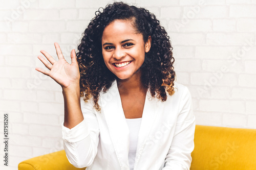 Beautiful african american black woman smiling at camera waving and saying hello to you photo