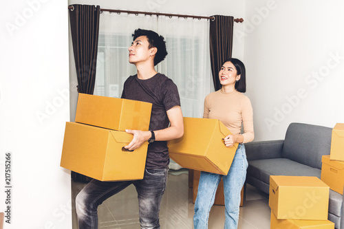 Happy young couple carrying boxes and moving into their new home.House moving and real estate concept photo