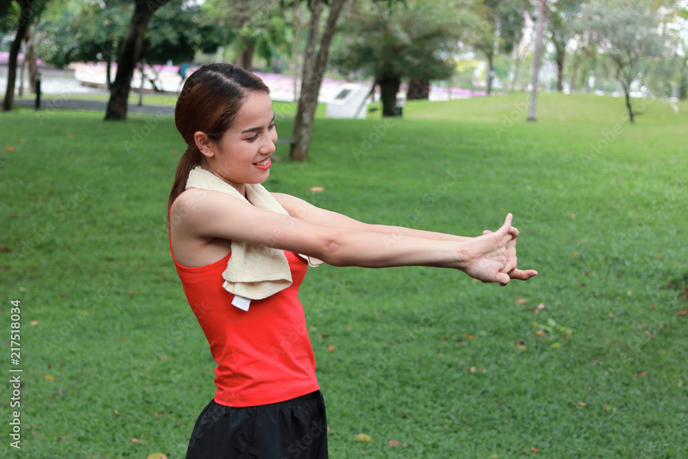 Fitness young Asian woman stretching her hands before run in park. Workout and exercise concept. Fitness young Asian woman stretching her hands before run in park. Workout and exercise concept.