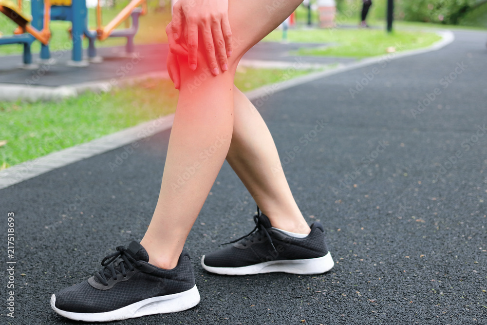Fitness woman runner suffering from broken knee. Running injury accident concept.