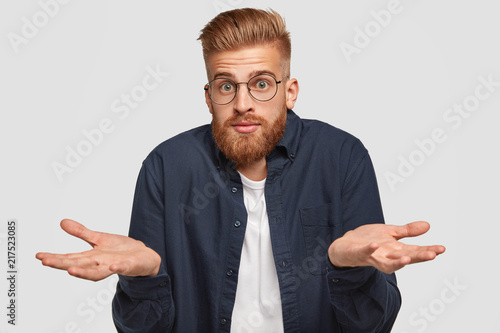 Εκτύπωση καμβά Indoor shot of handsome puzzled young ginger man with clueless expression, feels