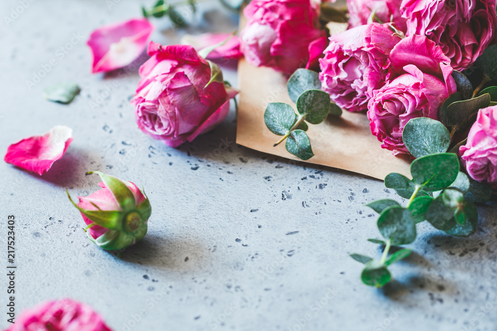 Pink roses in the envelope on a grey background. The concept of greetings and celebration. Copy space, soft focus. Pink roses in the envelope on a grey background. The concept of greetings and celebration. Copy space, soft focus.