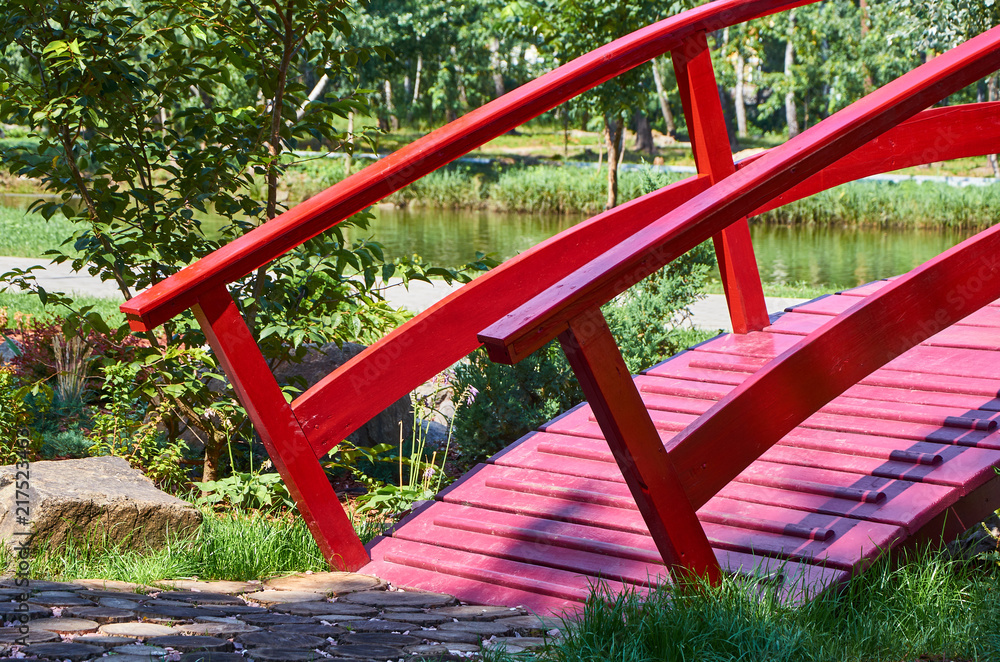 wooden red decorative bridge across the pond