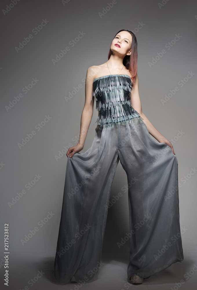 Fashion portrait in full growth, beautiful young woman in wide pants. Stylish in appearance Fashion portrait in full growth, beautiful young woman in wide pants. Stylish in appearance