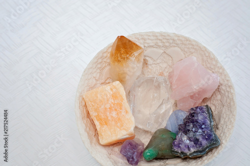 Healing crystals on a white table including  Amethyst Point and Cluster  Clear Quartz  Citrine  Calcite and Rose quartz. Gemstones are full of healing energy and good vibes.