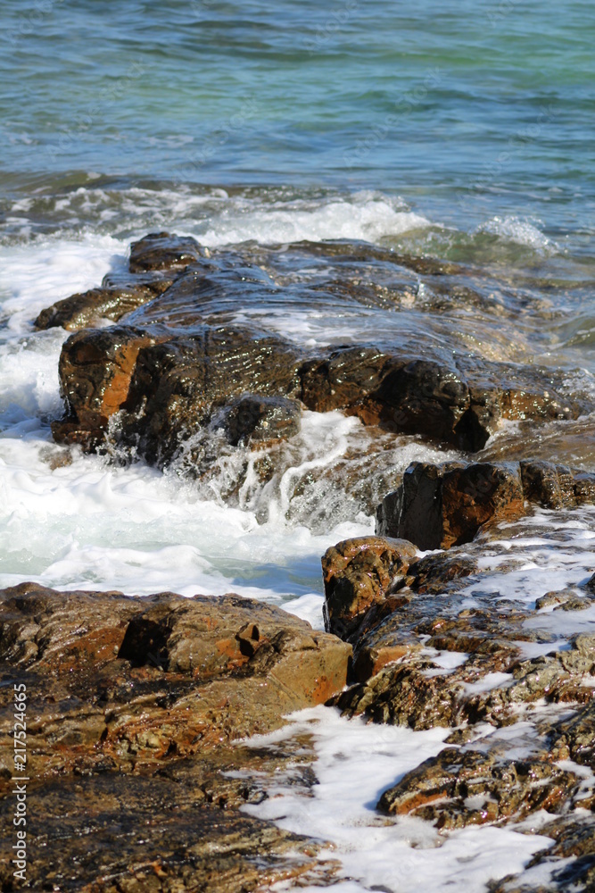Fototapeta premium sea foam over red rocks 