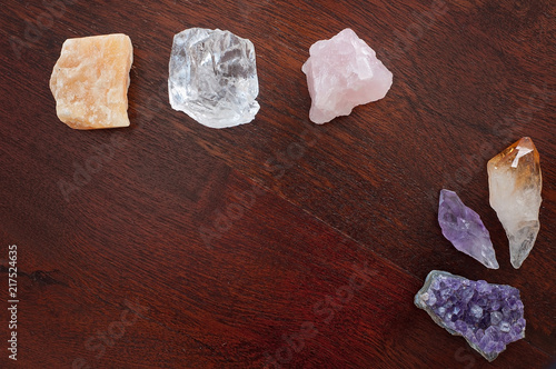 Healing crystals on a table including: Amethyst Point and Cluster, Clear Quartz, Citrine, Calcite and Rose quartz. Gemstones are full of healing energy and good vibes.